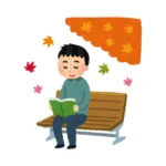 man reading a kanji book underneath a tree